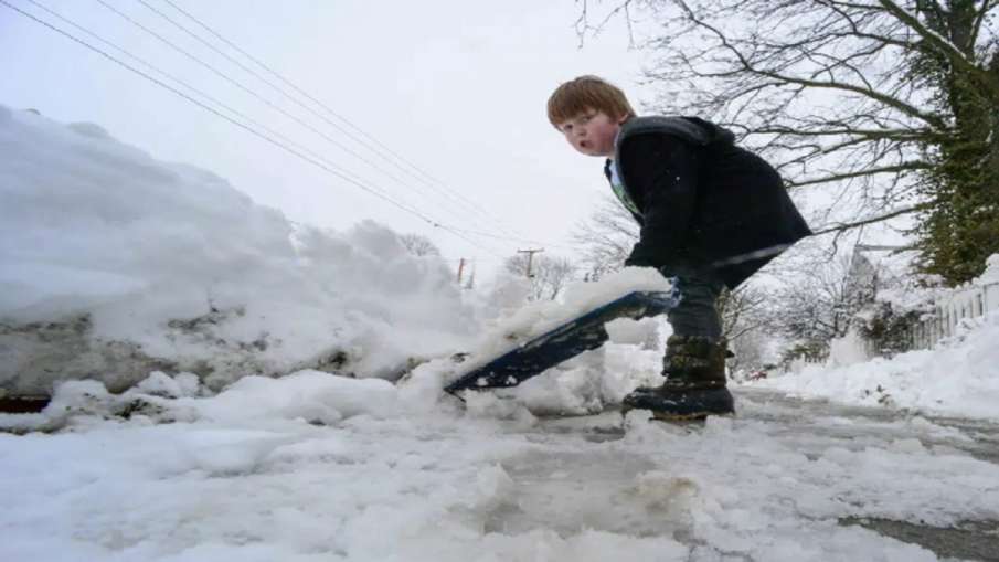 बर्फ हटाने में छोटे बच्चे भी बड़ों के साथ मदद में जुटे हुए हैं।